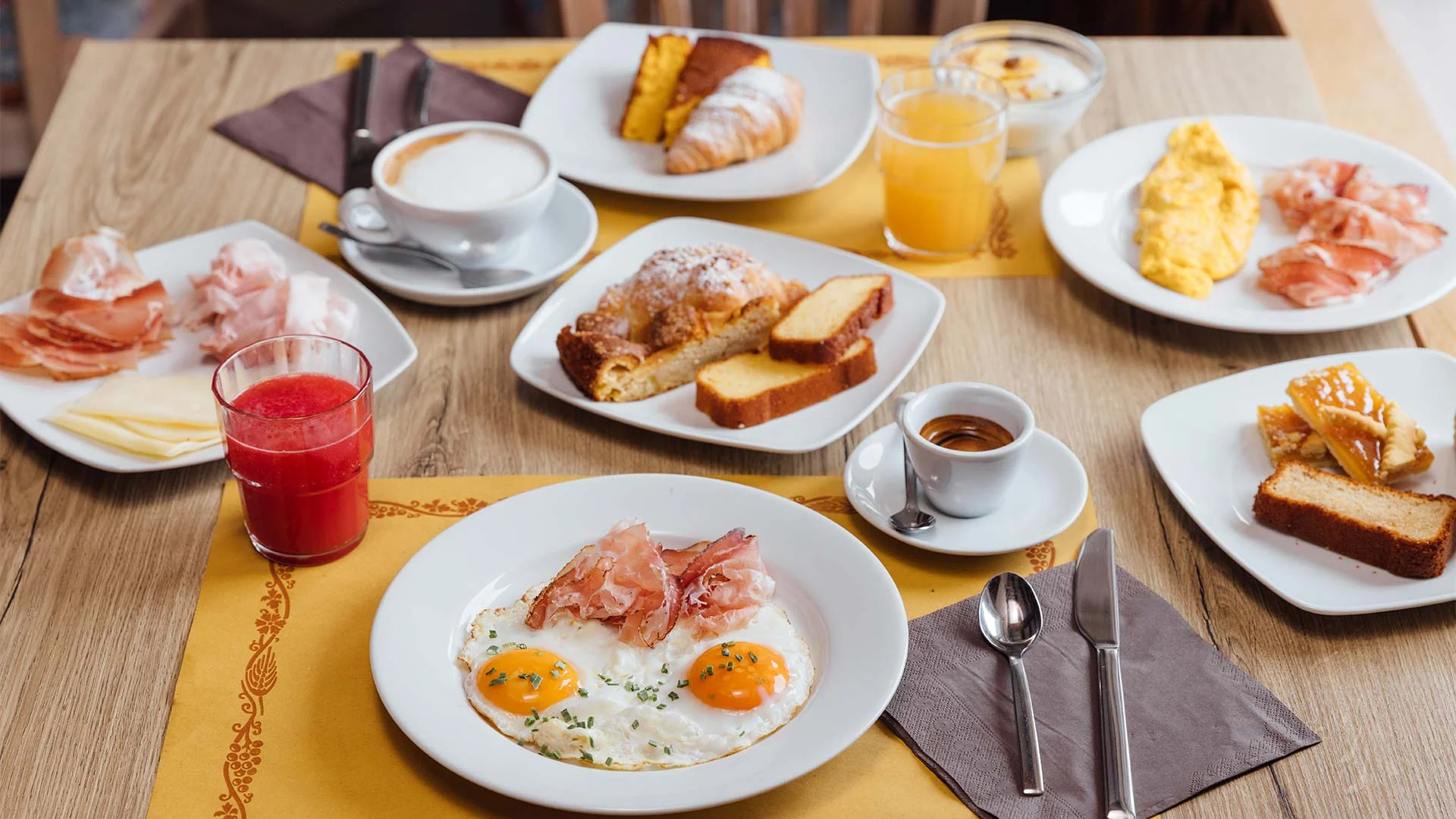 Torte, brioche, succhi e caffè sulla tavola della colazione