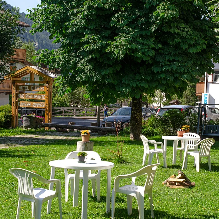 Tavolini e area verde nel giardino dell’Hotel Europa