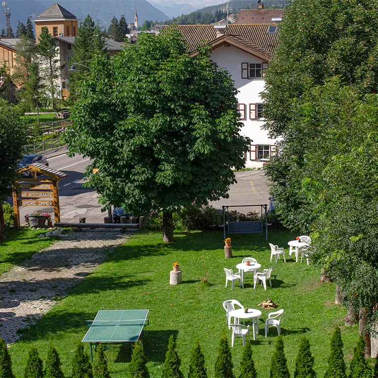 Il giardino soleggiato dell’hotel con alberi e tavolini