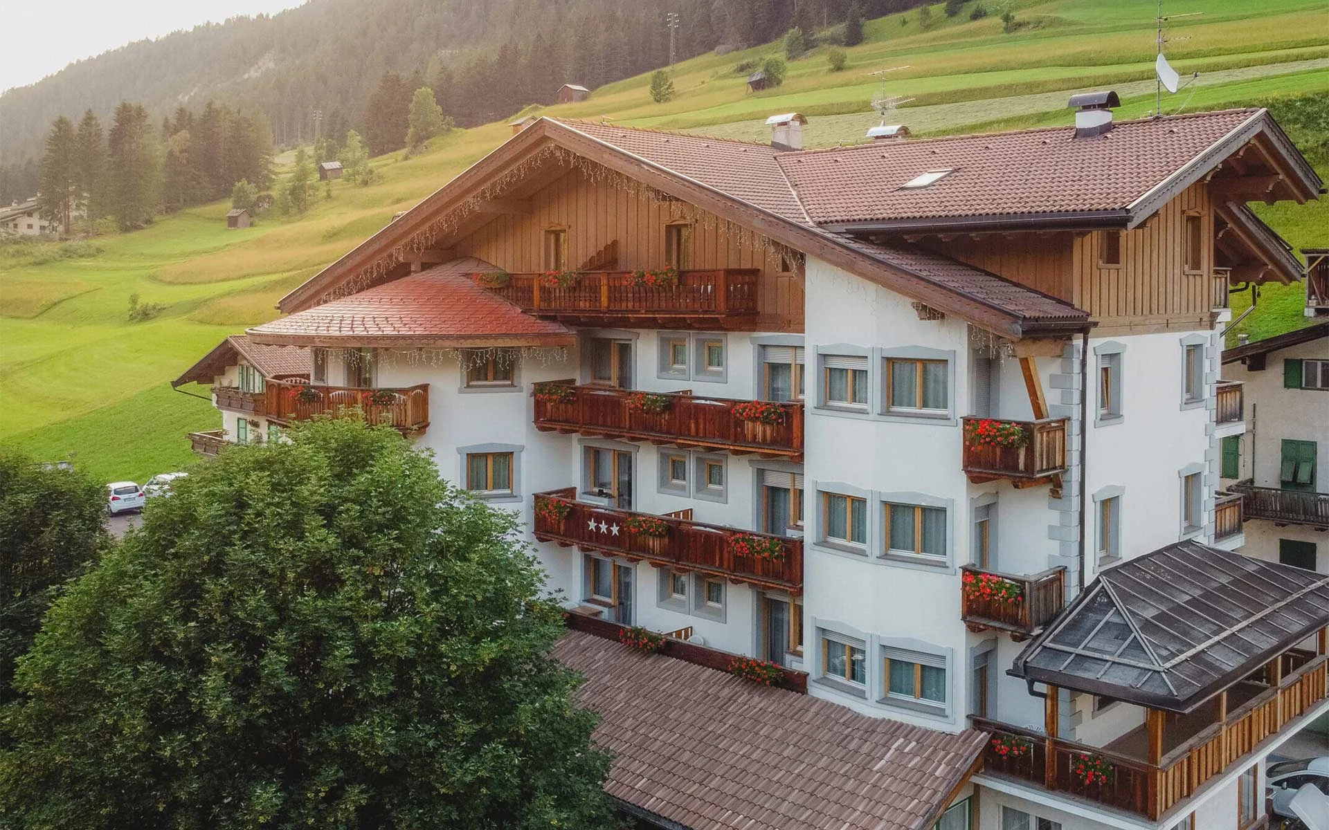 Hotel Europa in estate, immerso nel verde di Pera di Fassa